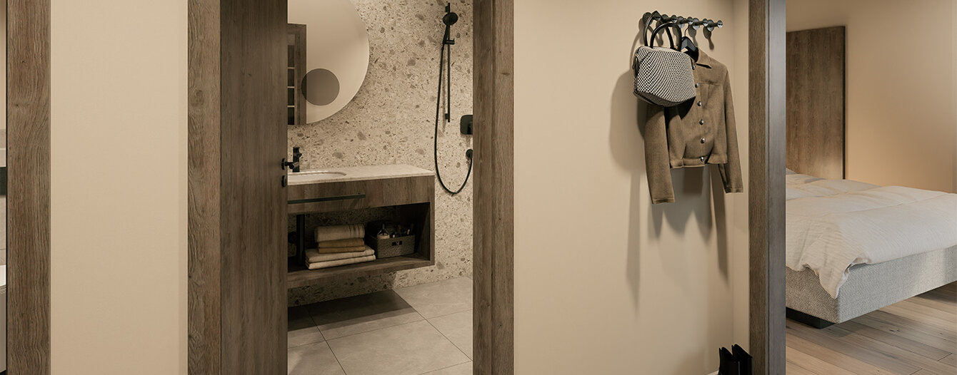 Moderner Flur mit beigen Wänden und Holzverkleidung, mit offenen Türen zu einem Badezimmer mit einem Waschbecken und einem Schlafzimmer mit einem gemachten Bett. Eine Wandgarderobe und ein Paar schwarze Schuhe sind zu sehen.