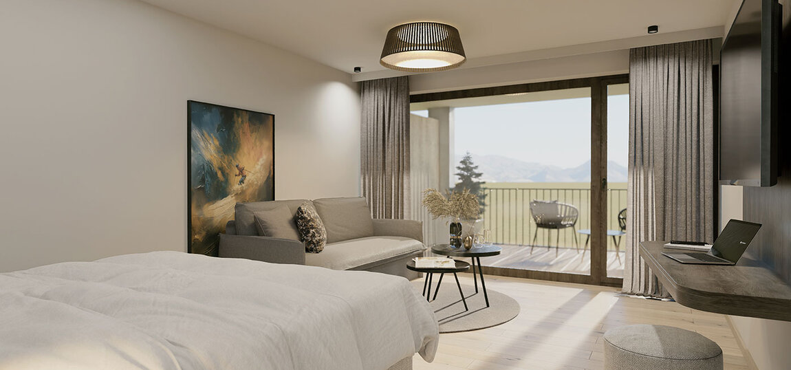 Ein modernes Zimmer mit einem Bett, einem Sofa, einem kleinen Tisch, einem an der Wand montierten Fernseher und Balkontüren mit Blick auf die Berge. Helle Holzböden, neutrale Töne und eine moderne Einrichtung schaffen eine gemütliche Atmosphäre.