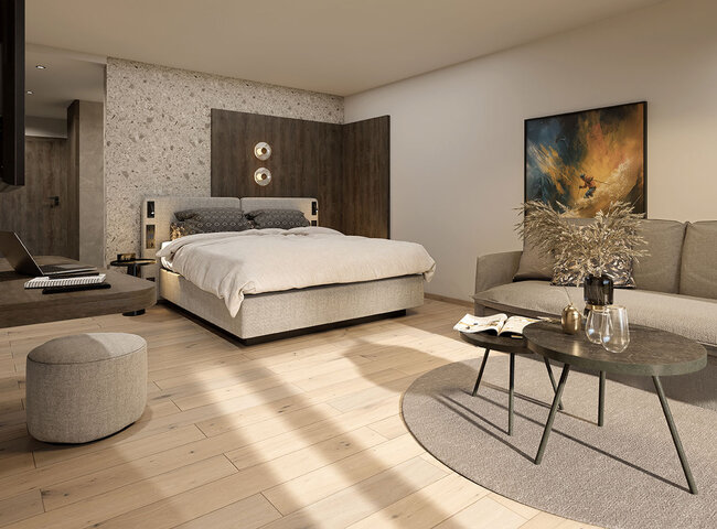 Modernes Schlafzimmer mit einem großen Bett, grauem Kopfteil, neutraler Bettwäsche, einem Sofa, runden Couchtischen, einem Hocker und abstrakten Kunstwerken an der Wand. Helle Holzböden und sanfte Beleuchtung schaffen eine gemütliche Atmosphäre.