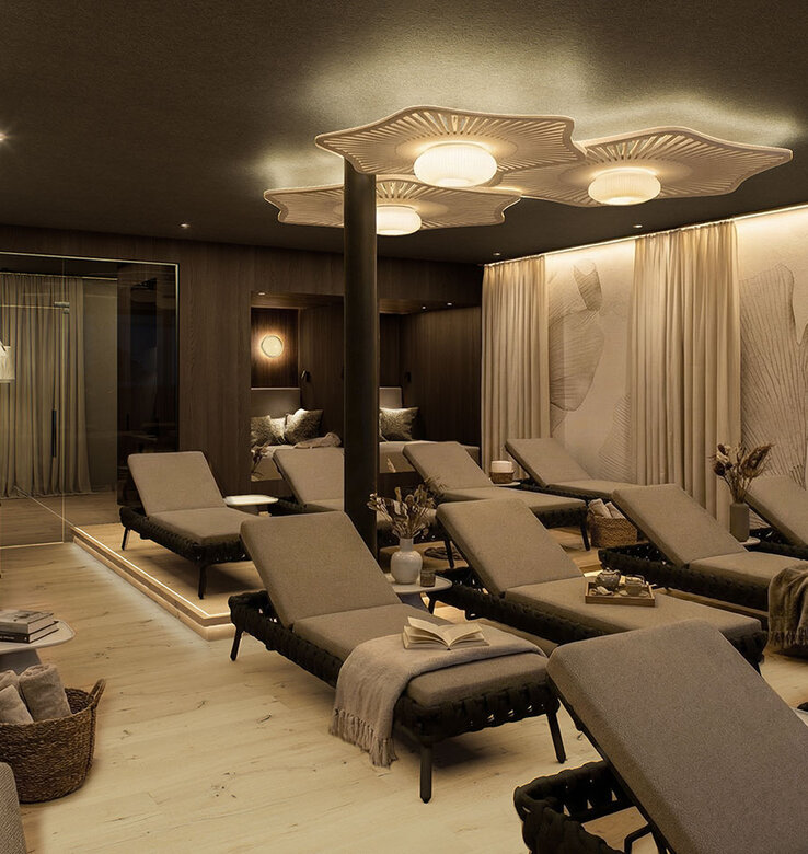 Eine moderner Ruheraum mit mehreren gepolsterten Liegestühlen, weichen beigen Vorhängen, warmer Beleuchtung und modernen Deckenleuchten, die eine entspannende und ruhige Atmosphäre schaffen.