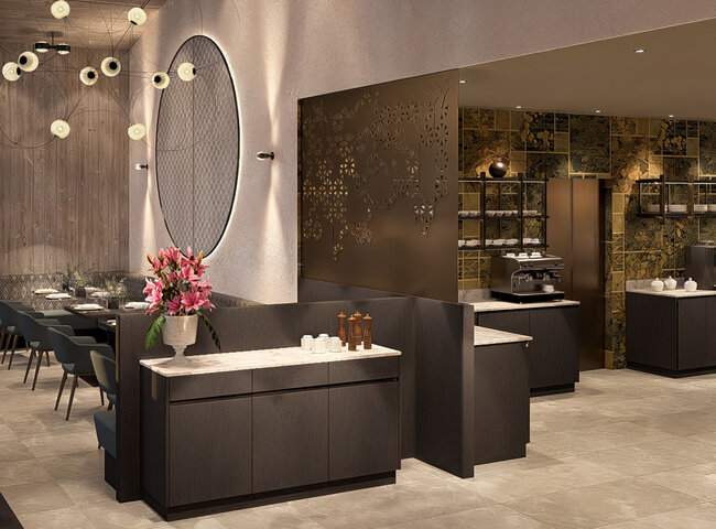 Modernes Restaurantinterieur mit eleganten dunklen Holzmöbeln, einer großen runden Wanddekoration, rosa Blumen auf einem Tresen, Pendelleuchten und einem Kaffeemaschinenbereich vor einer goldgemusterten Wand im Hintergrund.