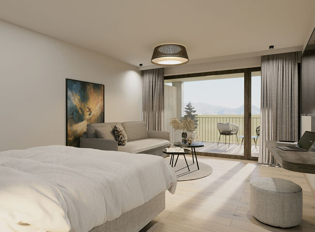 Ein modernes Zimmer mit einem Bett, einem grauen Sofa, einem runden Couchtisch, einem an der Wand montierten Fernseher und einem Balkon mit Sitzgelegenheit. Große Fenster lassen natürliches Licht herein und bieten einen Blick auf die Berge und Bäume.