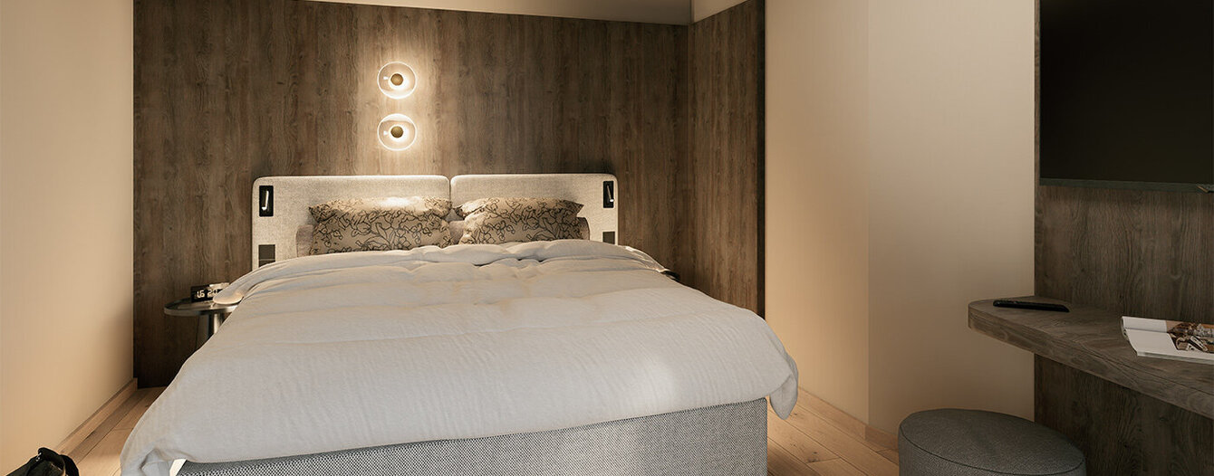 Modernes Schlafzimmer mit großem Bett, neutraler Bettwäsche, holzgetäfelter Akzentwand, Einbauschrank, Wandlampe, an der Wand montiertem Flachbildfernseher und einer kleinen runden Sessel neben einem Schreibtisch.